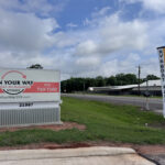 Roadside signs advertising boat and RV storage with a blue sky and clouds in the background