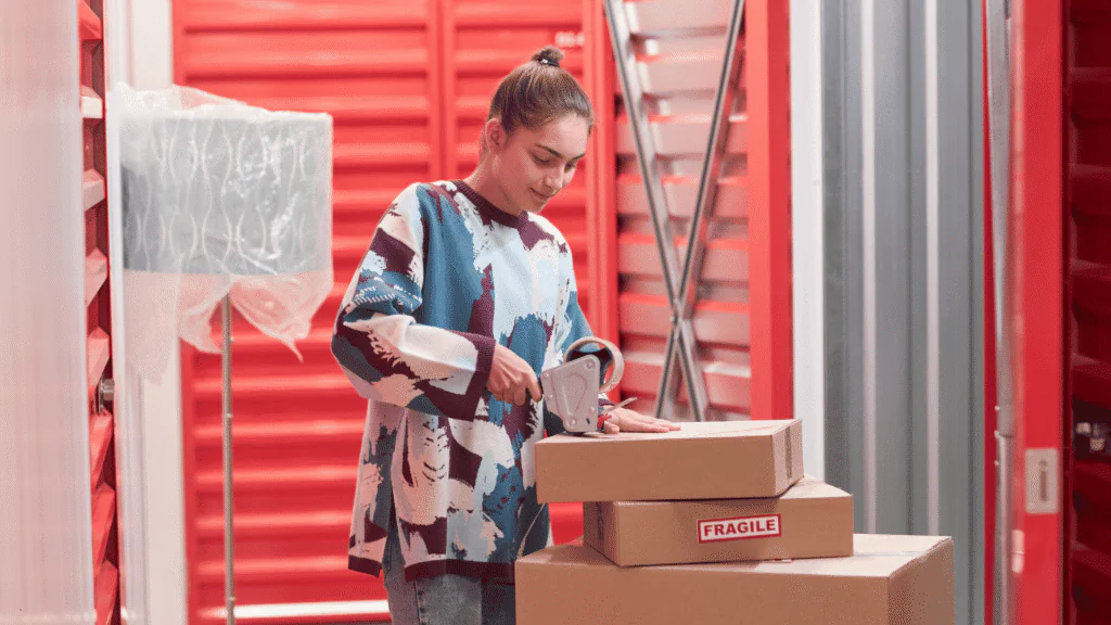 Person packing and organizing product boxes in a self storage unit as part of side hustle storage solutions